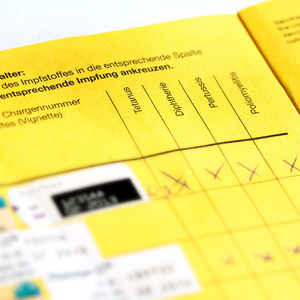 Aufgeklappter Impfausweis Ein aufgeklappter Impfausweis liegt auf einem Tisch.